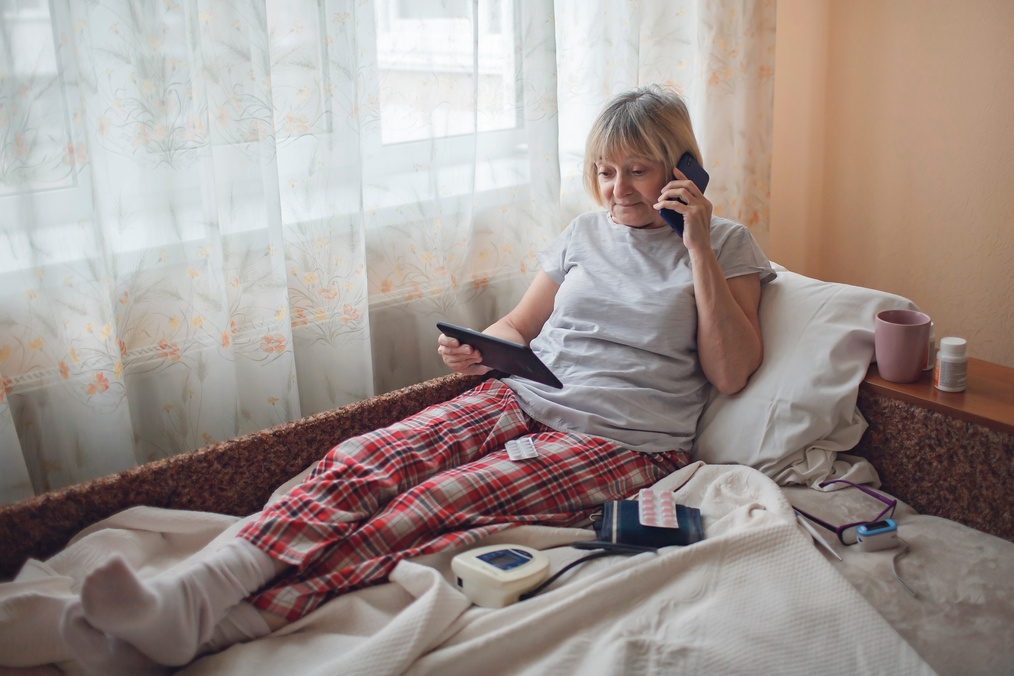 Old Woman in Bed Having Medical Teleconsultation